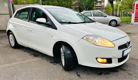 Autómosó mellett fotózott fehér autó zavaró háttérrel